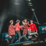 FTISLAND、CNBLUE、SF9らが所属するFNC エンターテインメント所属のアーティストが集う音楽の祭典『2017 FNC KINGDOM IN JAPAN -MIDNIGHT CIRCUS-』が 12月16日・17日に千葉県・幕張メッセで開催され、2日間で20,000人を魅了した。 5周年という節目を迎えたFNC KINGDOMは、所属アーティストのライブを1日で見られるだけでなく、 グループの垣根を超えた、ここでしか見られないアーティストのコラボレーションステージやスペシャルステージが目白押しのイベント。 今年は<KINGDOM(王国)で真夜中に開催されるサーカス>をテーマに、FTISLAND、CNBLUE、AOA、N.Flying、SF9、HONEYSTら6組が出演した。 6人のピエロに導かれスタートしたのは、勇壮なリズムを刻むパーカッションセッション。ミンファン(FTISLAND)、ミンヒョク(CNBLUE)、ジェヒョン(N.Flying)、スンソク(HONEYST)という4バンドのドラマーが一堂に会した貴重なコラボを幕開けに、出演グループが登場。 「ようこそ、『2017 FNC KINGDOM IN JAPAN -MIDNIGHT CIRCUS-』へ!」(ヨンファ)、「ファミリーコンサート、今から始まります!」(ホンギ)と、FNCを代表するフロントマン2人が開会を宣言した。 様々なグループのライブや豪華コラボが行われた中で、5周年のアニバーサリーを彩ったのは、イ・ホンギ(FTISLAND)とジョン・ヨンファ(CNBLUE)によるドラマ『美男<イケメン>ですね』の作中バンドA.N.JELLのジェルミとシヌの復活だ。ドラマの主題歌「Promise」では投げキスを模した振付まで披露し、歌いながらお互いの肩に手を置いたりと、仲の良さをうかがわせる。トークではドラマで彼らが演じた役になりきり、「今日は2人だけど、テギョン(チャン・グンソク)さんとミナム(パク・シネ)さんと4人で、いつか東京ドームでライブしましょう! 僕の夢ですから」と意気込むヨンファに、「A.N.JELLは3曲しかないのに⁈ でも、いろんなジャンルにアレンジすれば3曲で2時間できるかな?」とホンギがアイディアを出せばファンは爆笑。A.N.JELL復活に対する会場の反応の大きさにホンギは、「実は昨日のステージの後、2日目もやってほしいって言われたんです。FTISLANDもCNBLUEも頑張ってたんだけど、A.N.JELLが一番良かったからって」とゴキゲン。なりきりトークを続けているとヨンファが、「ホンギさん、ありがとうございます。何も知らない僕にホンギ先輩がいろいろ教えてくれました。ホンギがいるから僕がいる、(FNCアーティスト第1号の)ホンギがいるからFNCの他のアーティストもいるんです」とデビュー作である本作を思い出し急に素に戻ってマジメな話をしだすと、ホンギは「わー、トリハダ」と笑いながら照れ隠しをする。ドラマの思い出話では、ヨンファが好きなシーンだという明洞(ミョンドン)でミナム(パク・シネ)の後をシヌがつけるドラマの名場面を再現して「なつかしー!」と大爆笑しながら、「撮影は楽しくて、辛いことはなかった。4人はすごく仲が良くて、台本にないアドリブもたくさんやったし」(ホンギ)と、思い出話に花が咲いた。2曲目の「Still」では、8年前のドラマの場面写真が映し出されると会場からは大きな歓声が上がり、最後にホンギが「今度会えるのは、いつになるかわからないけど」と言いながら2人で肩を組んで「ジェルミ~」、「シヌ~」と言い合いながら退場していったが、2人が揃ってA.N.JELLの曲を歌うのはドラマ撮影時以降初、約8年ぶりとなり、FNC KINGDOMだからこそ、5周年だからこそできた復活劇となった。 他にも、普段はドラマーとしてステージの中央に立つことがないミンファン(FTISLAND)を中心に、ジェヒョン&フェスン(N.Flying)、ダウォン(SF9)らが嵐の「Love so sweet」をカバーしたり、ギタリストのジョンフン(FTISLAND)がギターを持たずにヨンビン&ジェユン(SF9)を従えて星野源の「恋」ダンスを披露するという意外性のあるコラボや、実力派女性ラッパーとして注目されているジミン(AOA)がスンヒョプ(N.Flying)、ジュホ(SF9)を従えたステージ、ユナ(AOA)とインソン(SF9)がボーカルをたっぷり聴かせるスペシャルコラボなど、普段とは違ったカラーの楽曲を見せてくれた。 FNCの重鎮として、ガッツリしたライブを見せてくれたのは、FTISLANDとCNBLUE。初日はCNBLUEがトリ、2日目はFTISLANDがトリを務めたが、ライブで売っているバンドだけに両日でセットリストを変えて異なるライブを展開した。 CNBLUEは、とにかく楽しさが爆発。ステージの上、そしてステージを降りて、ファンの近くをくまなく走り回り、ファンにコール&レスポンスを求めるヨンファ。そのヨンファはトーク中もFTISLANDやSF9の曲を即興でピアノ弾き語りを始めたかと思えば、「今日、来てくれたみなさんが熱いから、帰りたくない! 朝までやりましょう!」と、セットリストに入っていないライブのテッパン曲「Wake Up」を始めたり、音楽を奏でるのが楽しくてしかたがない様子で、CNBLUEもファンも完全燃焼できるライブで盛り上げた。 CNBLUEからは、ソロアルバムをリリースしているボーカルのヨンファとギターのジョンヒョンが、ソロステージも披露。 ジョンヒョンは1月にリリースされる2ndソロアルバム『METROPOLIS』に収録されるアコースティックなバラードナンバー「ひかりのまちで」をライブで初パフォーマンスして会場を沸かせた。 FTISLANDは、音楽でひとつになれる勢いのあるライブを展開。初日はファンがコーラスに参加できる曲を多めに、2日目は彼ら得意のハードなロック曲を中心に聴かせたが、ボーカル、ホンギのバラードからロックまでを歌いあげる声と、ファンの心を捉えるパフォーマンスとトーク力はサスガ。「FTISLANDは音楽を多様な色に変えることができるバンド。FNC KINGDOMもどんどんFNCの色をみつけていっている。俺はやりたくないけど、“FNCのアーティストみんなが同じステージに集まれるのはFNC KINGDOMしかないから”ってCNBLUEのヨンファに説得されて参加しています。ヨンファがFNCの天使で、俺が悪魔だな(笑)」とファンを笑わせたが、なんとか言いながらもFNC愛が一番あふれているのがFNC第一号アーティストであるのFTISLANDのホンギなのだ。「今年も来てくれてありがとう。全員がこれからも、もっといい音楽をプレゼントします」と言って、この日誕生日を迎えたベースのジェジンへのお祝いも兼ねて、1万人と声を合わせて「FNCファイティン! ジェジン、誕生日おめでとう!」とステージ上でカンパイをしてライブをしめくくった。 FTISLANDからは、ソロアルバムをリリースしているホンギもソロステージを披露。心に響くバラードを熱唱した。 今年、イッキにファンが増えたのを実感させたのは6月に日本デビューしたSF9。12月13日にリリースしたばかりの日本1stアルバムの収録曲「僕の太陽 ~O Sole Mio~」などで大きなファンコールを集めたが、自曲のほかに、ブルゾンちえみでおなじみのオースティン・マホーンの「Dirty Work」をカバー。ラストでジミン(AOA)が登場し、かわいく「35億」をキメた。新人であるSF9は前述のコラボの他にも、CNBLUE、ヨンファのソロなど先輩たちのステージでのコラボでも大活躍した。 N.Flyingは、韓国で大ブームを巻き起こしたデビューサバイバル番組『PRODUCE 101 Season2』出身のフェスンが加入してから初のFNC KINGDOM。ボーカルをフェスンにバトンタッチしたグァンジンがベースに専念することで演奏がタイトになり、磨きがかかったツインボーカルで華やかさが増した印象。「バンドが楽しくて、すごく幸せ」というフェスンの言葉に象徴されるように、今後の彼らの飛躍が楽しみになる。 1年ぶりの来日となるAOAも、待ちわびたファンの前で久々のパフォーマンスを見せたが、「今年はいろいろ大変でしたが、みんな気持ちをひとつにして頑張っています。 戻ってくるので忘れずに待っていてください」と再会を約束してくれた。 まだ日本での活動をしていない新人バンドHONEYSTは、新曲「恋愛したい」など2曲をパフォーマンスしたが、先輩バンドたちとはまた違う爽やかなロックを聴かせた。 エンディングでは再びステージの上に全アーティストが大集結。 最後にホンギ&ヨンファが登場すると、「今年も幸せに終えることができました」(ホンギ)、「来年、また会いましょう!」(ヨンファ)と言って約5時間のファミリーコンサートの幕が閉じた。 なお、このFNC KINGDOMが年内の日本でのライブが最後になるアーティストが多い中、12月13日に1stアルバム『Sensational Feeling Nine』をリリースしたばかりのSF9は、12月21日・福岡、22日・名古屋、23日・大阪、24日・東京でアルバムのリリースイベントを開催、CNBLUEのヨンファは、20日、21日にパシフィコ横浜国立大ホールで『JUNG YONG HWA JAPAN CONCERT 2017 "Summer Calling" @Xmas』を行い、年内の日本活動を終える予定。