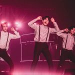 FTISLAND、CNBLUE、SF9らが所属するFNC エンターテインメント所属のアーティストが集う音楽の祭典『2017 FNC KINGDOM IN JAPAN -MIDNIGHT CIRCUS-』が 12月16日・17日に千葉県・幕張メッセで開催され、2日間で20,000人を魅了した。 5周年という節目を迎えたFNC KINGDOMは、所属アーティストのライブを1日で見られるだけでなく、 グループの垣根を超えた、ここでしか見られないアーティストのコラボレーションステージやスペシャルステージが目白押しのイベント。 今年は<KINGDOM(王国)で真夜中に開催されるサーカス>をテーマに、FTISLAND、CNBLUE、AOA、N.Flying、SF9、HONEYSTら6組が出演した。 6人のピエロに導かれスタートしたのは、勇壮なリズムを刻むパーカッションセッション。ミンファン(FTISLAND)、ミンヒョク(CNBLUE)、ジェヒョン(N.Flying)、スンソク(HONEYST)という4バンドのドラマーが一堂に会した貴重なコラボを幕開けに、出演グループが登場。 「ようこそ、『2017 FNC KINGDOM IN JAPAN -MIDNIGHT CIRCUS-』へ!」(ヨンファ)、「ファミリーコンサート、今から始まります!」(ホンギ)と、FNCを代表するフロントマン2人が開会を宣言した。 様々なグループのライブや豪華コラボが行われた中で、5周年のアニバーサリーを彩ったのは、イ・ホンギ(FTISLAND)とジョン・ヨンファ(CNBLUE)によるドラマ『美男<イケメン>ですね』の作中バンドA.N.JELLのジェルミとシヌの復活だ。ドラマの主題歌「Promise」では投げキスを模した振付まで披露し、歌いながらお互いの肩に手を置いたりと、仲の良さをうかがわせる。トークではドラマで彼らが演じた役になりきり、「今日は2人だけど、テギョン(チャン・グンソク)さんとミナム(パク・シネ)さんと4人で、いつか東京ドームでライブしましょう! 僕の夢ですから」と意気込むヨンファに、「A.N.JELLは3曲しかないのに⁈ でも、いろんなジャンルにアレンジすれば3曲で2時間できるかな?」とホンギがアイディアを出せばファンは爆笑。A.N.JELL復活に対する会場の反応の大きさにホンギは、「実は昨日のステージの後、2日目もやってほしいって言われたんです。FTISLANDもCNBLUEも頑張ってたんだけど、A.N.JELLが一番良かったからって」とゴキゲン。なりきりトークを続けているとヨンファが、「ホンギさん、ありがとうございます。何も知らない僕にホンギ先輩がいろいろ教えてくれました。ホンギがいるから僕がいる、(FNCアーティスト第1号の)ホンギがいるからFNCの他のアーティストもいるんです」とデビュー作である本作を思い出し急に素に戻ってマジメな話をしだすと、ホンギは「わー、トリハダ」と笑いながら照れ隠しをする。ドラマの思い出話では、ヨンファが好きなシーンだという明洞(ミョンドン)でミナム(パク・シネ)の後をシヌがつけるドラマの名場面を再現して「なつかしー!」と大爆笑しながら、「撮影は楽しくて、辛いことはなかった。4人はすごく仲が良くて、台本にないアドリブもたくさんやったし」(ホンギ)と、思い出話に花が咲いた。2曲目の「Still」では、8年前のドラマの場面写真が映し出されると会場からは大きな歓声が上がり、最後にホンギが「今度会えるのは、いつになるかわからないけど」と言いながら2人で肩を組んで「ジェルミ~」、「シヌ~」と言い合いながら退場していったが、2人が揃ってA.N.JELLの曲を歌うのはドラマ撮影時以降初、約8年ぶりとなり、FNC KINGDOMだからこそ、5周年だからこそできた復活劇となった。 他にも、普段はドラマーとしてステージの中央に立つことがないミンファン(FTISLAND)を中心に、ジェヒョン&フェスン(N.Flying)、ダウォン(SF9)らが嵐の「Love so sweet」をカバーしたり、ギタリストのジョンフン(FTISLAND)がギターを持たずにヨンビン&ジェユン(SF9)を従えて星野源の「恋」ダンスを披露するという意外性のあるコラボや、実力派女性ラッパーとして注目されているジミン(AOA)がスンヒョプ(N.Flying)、ジュホ(SF9)を従えたステージ、ユナ(AOA)とインソン(SF9)がボーカルをたっぷり聴かせるスペシャルコラボなど、普段とは違ったカラーの楽曲を見せてくれた。 FNCの重鎮として、ガッツリしたライブを見せてくれたのは、FTISLANDとCNBLUE。初日はCNBLUEがトリ、2日目はFTISLANDがトリを務めたが、ライブで売っているバンドだけに両日でセットリストを変えて異なるライブを展開した。 CNBLUEは、とにかく楽しさが爆発。ステージの上、そしてステージを降りて、ファンの近くをくまなく走り回り、ファンにコール&レスポンスを求めるヨンファ。そのヨンファはトーク中もFTISLANDやSF9の曲を即興でピアノ弾き語りを始めたかと思えば、「今日、来てくれたみなさんが熱いから、帰りたくない! 朝までやりましょう!」と、セットリストに入っていないライブのテッパン曲「Wake Up」を始めたり、音楽を奏でるのが楽しくてしかたがない様子で、CNBLUEもファンも完全燃焼できるライブで盛り上げた。 CNBLUEからは、ソロアルバムをリリースしているボーカルのヨンファとギターのジョンヒョンが、ソロステージも披露。 ジョンヒョンは1月にリリースされる2ndソロアルバム『METROPOLIS』に収録されるアコースティックなバラードナンバー「ひかりのまちで」をライブで初パフォーマンスして会場を沸かせた。 FTISLANDは、音楽でひとつになれる勢いのあるライブを展開。初日はファンがコーラスに参加できる曲を多めに、2日目は彼ら得意のハードなロック曲を中心に聴かせたが、ボーカル、ホンギのバラードからロックまでを歌いあげる声と、ファンの心を捉えるパフォーマンスとトーク力はサスガ。「FTISLANDは音楽を多様な色に変えることができるバンド。FNC KINGDOMもどんどんFNCの色をみつけていっている。俺はやりたくないけど、“FNCのアーティストみんなが同じステージに集まれるのはFNC KINGDOMしかないから”ってCNBLUEのヨンファに説得されて参加しています。ヨンファがFNCの天使で、俺が悪魔だな(笑)」とファンを笑わせたが、なんとか言いながらもFNC愛が一番あふれているのがFNC第一号アーティストであるのFTISLANDのホンギなのだ。「今年も来てくれてありがとう。全員がこれからも、もっといい音楽をプレゼントします」と言って、この日誕生日を迎えたベースのジェジンへのお祝いも兼ねて、1万人と声を合わせて「FNCファイティン! ジェジン、誕生日おめでとう!」とステージ上でカンパイをしてライブをしめくくった。 FTISLANDからは、ソロアルバムをリリースしているホンギもソロステージを披露。心に響くバラードを熱唱した。 今年、イッキにファンが増えたのを実感させたのは6月に日本デビューしたSF9。12月13日にリリースしたばかりの日本1stアルバムの収録曲「僕の太陽 ~O Sole Mio~」などで大きなファンコールを集めたが、自曲のほかに、ブルゾンちえみでおなじみのオースティン・マホーンの「Dirty Work」をカバー。ラストでジミン(AOA)が登場し、かわいく「35億」をキメた。新人であるSF9は前述のコラボの他にも、CNBLUE、ヨンファのソロなど先輩たちのステージでのコラボでも大活躍した。 N.Flyingは、韓国で大ブームを巻き起こしたデビューサバイバル番組『PRODUCE 101 Season2』出身のフェスンが加入してから初のFNC KINGDOM。ボーカルをフェスンにバトンタッチしたグァンジンがベースに専念することで演奏がタイトになり、磨きがかかったツインボーカルで華やかさが増した印象。「バンドが楽しくて、すごく幸せ」というフェスンの言葉に象徴されるように、今後の彼らの飛躍が楽しみになる。 1年ぶりの来日となるAOAも、待ちわびたファンの前で久々のパフォーマンスを見せたが、「今年はいろいろ大変でしたが、みんな気持ちをひとつにして頑張っています。 戻ってくるので忘れずに待っていてください」と再会を約束してくれた。 まだ日本での活動をしていない新人バンドHONEYSTは、新曲「恋愛したい」など2曲をパフォーマンスしたが、先輩バンドたちとはまた違う爽やかなロックを聴かせた。 エンディングでは再びステージの上に全アーティストが大集結。 最後にホンギ&ヨンファが登場すると、「今年も幸せに終えることができました」(ホンギ)、「来年、また会いましょう!」(ヨンファ)と言って約5時間のファミリーコンサートの幕が閉じた。 なお、このFNC KINGDOMが年内の日本でのライブが最後になるアーティストが多い中、12月13日に1stアルバム『Sensational Feeling Nine』をリリースしたばかりのSF9は、12月21日・福岡、22日・名古屋、23日・大阪、24日・東京でアルバムのリリースイベントを開催、CNBLUEのヨンファは、20日、21日にパシフィコ横浜国立大ホールで『JUNG YONG HWA JAPAN CONCERT 2017 "Summer Calling" @Xmas』を行い、年内の日本活動を終える予定。
